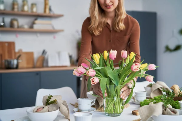 Kavkazská Žena Klade Vázu Čerstvými Tulipány Stůl — Stock fotografie