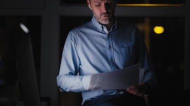 Kafkasyalı yetişkin işadamı ofiste geç saatlere kadar çalışıyor. 8K 'da kırmızı helyum kamerayla çekildi.. 