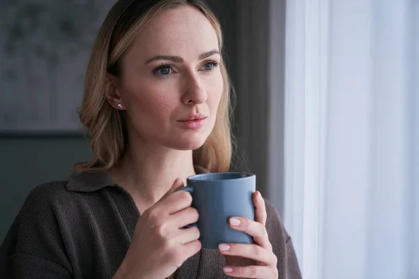 Närbild Omtänksam Kvinna Som Står Med Kopp Kaffe Bredvid Fönstret — Stockfoto