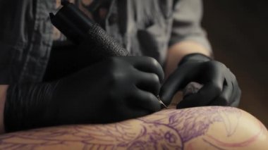 Müşterinin koluna dövme yapan ressamı kapat. 8K 'da kırmızı helyum kamerayla çekildi..  