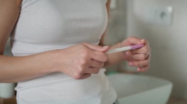Hamilelik testi sonuçlarını bekleyen tanınmayacak kadar stresli bir kadının elleri. 8K 'da kırmızı helyum kamerayla çekildi..   