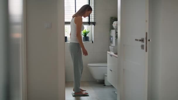 バスルームの規模に足を踏み入れる欲求不満な白人女性 8Kでレッドヘリウムカメラで撮影 — ストック動画