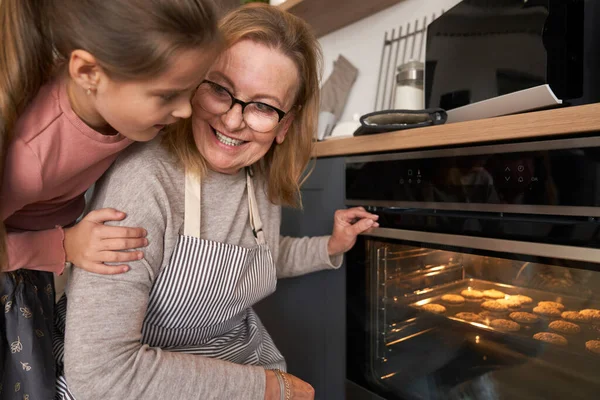 Kaukázusi Nagymama Unokája Ellenőrzi Sütiket Sütőben — Stock Fotó