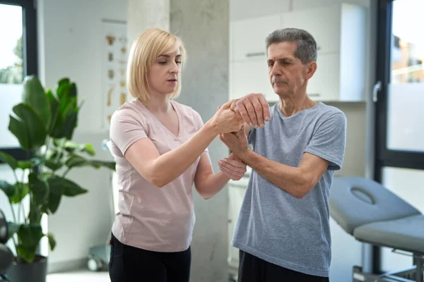 Close Van Vrouwelijke Fysiotherapeut Werken Met Senior Man — Stockfoto