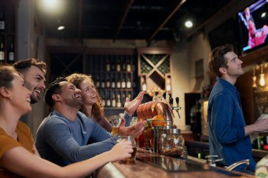 Bir grup arkadaş barda maç izliyor.  