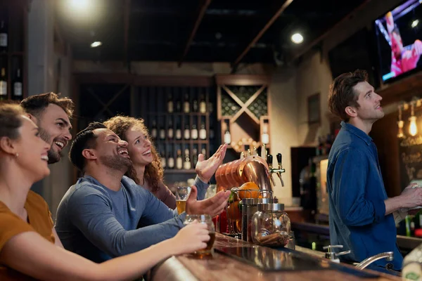 Bir grup arkadaş barda maç izliyor.  