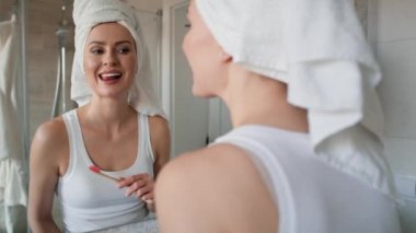 Beyaz kadın fırçaladıktan hemen sonra temiz dişleri kontrol ediyor. 8K 'da kırmızı helyum kamerayla çekildi..   