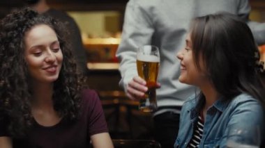 İki Kafkasyalı bayan arkadaş barda buluşuyor. 8K 'da kırmızı helyum kamerayla çekildi.. 