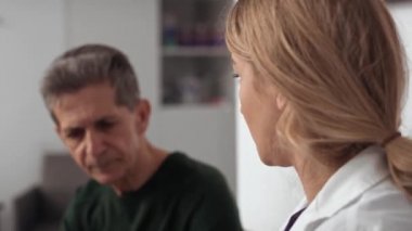 Kafkasyalı doktor ve hasta sonuçlar hakkında konuşuyor. 8K 'da kırmızı helyum kamerayla çekildi.. 