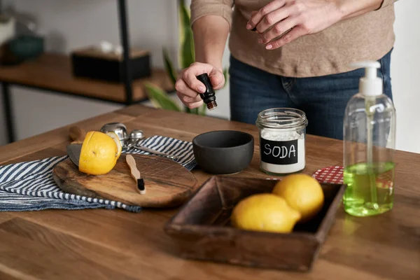 Tanınmayan kişi kaseye DIY temizlik ürünüyle gerekli yağı ekliyor.