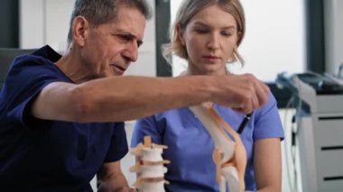 İki beyaz doktor konuşuyor ve tıbbi modelleri gösteriyor. 8K 'da kırmızı helyum kamerayla çekildi.. 