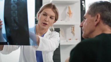 İki beyaz doktor röntgen görüntüsünü tartışıyor. 8K 'da kırmızı helyum kamerayla çekildi.. 