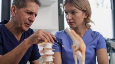 İki beyaz doktor konuşuyor ve tıbbi modelleri gösteriyor. 8K 'da kırmızı helyum kamerayla çekildi..