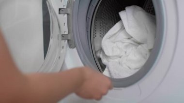 Beyaz bir kadının evde çamaşır yıkamasına yakın çekim. 8K 'da kırmızı helyum kamerayla çekildi..  