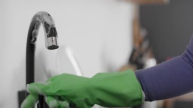 Beyaz kadın mutfak musluğunu temizliyor. 8K 'da kırmızı helyum kamerayla çekildi..  