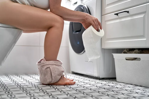 Detalhe Das Pernas Mulher Sentada Banheiro Segurando Rolo Papel Higiênico — Fotografia de Stock