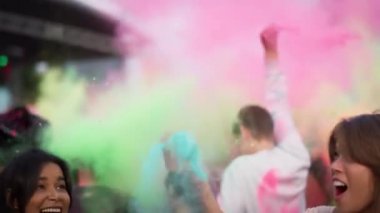 Bir grup arkadaş ellerinde renkli toz tutuyorlar ve Holi Festivali 'nde kusuyorlar. 8K 'da kırmızı helyum kamerayla çekildi..  