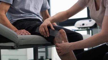 Hastasıyla çalışan kadın fizyoterapiste yakın çekim. 8K 'da kırmızı helyum kamerayla çekildi.. 