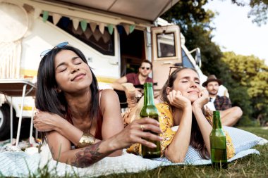 Genç arkadaşlar güneşin altında kampta vakit geçiriyorlar. 