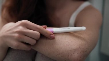 Banyoda hamilelik testi sonucunu bekleyen beyaz bir kadın var. 4K 'da kırmızı helyum kamerayla çekildi..    