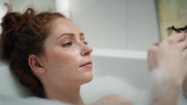 Caucasian Redhead Woman Taking Bath Reading Book Shot Red Helium — стоковое видео