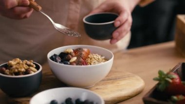 Kadın müsli kasesine tohum ekliyor. 