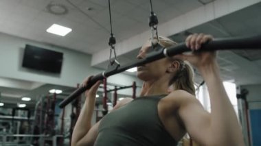 Young woman  exercising with weights  on a gym. Shot with RED helium camera in 8K. 