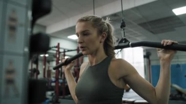 Young caucasian woman  exercising with weights  on a gym. Shot with RED helium camera in 8K.