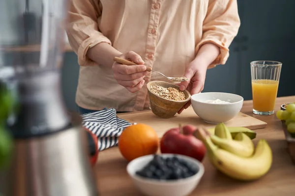 Mujer Agregando Muesli Tazón Con Yogur —  Fotos de Stock