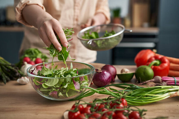 Close up woman making healthy salat at home 