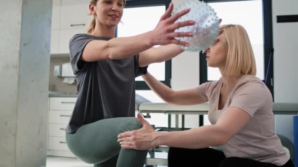 Female Physical Therapist Working Young Woman Using Exercising Ball Shot — Vídeo de stock