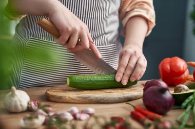 Mutfakta salatalık kesen bir kadının ellerine yaklaş.