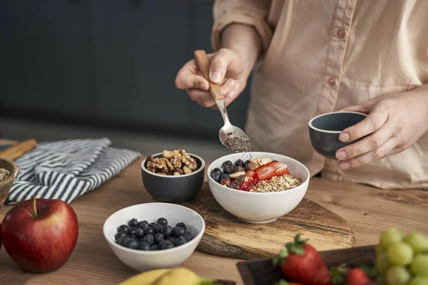 Woman Adding Seeds Bowl Muesli — Stockfoto