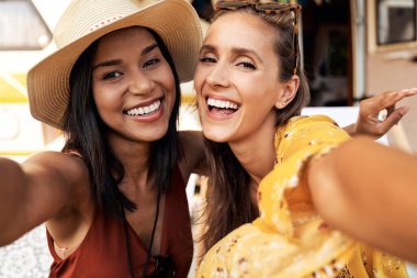 Yazın kamp alanında selfie çeken iki genç kadın.