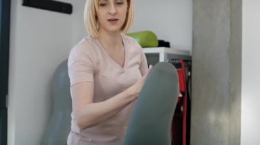 Bayan fizyoterapist hastasına bacak sorununda yardım ediyor. 8K 'da kırmızı helyum kamerayla çekildi..     