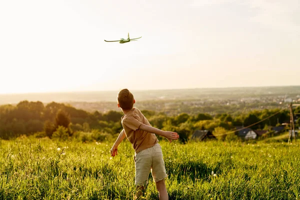 小男孩带着玩具飞机在草地上 — 图库照片