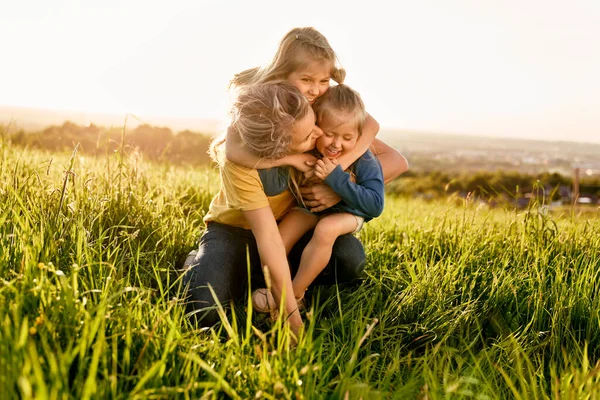 妈妈带着两个女儿在草地上共度时光 — 图库照片