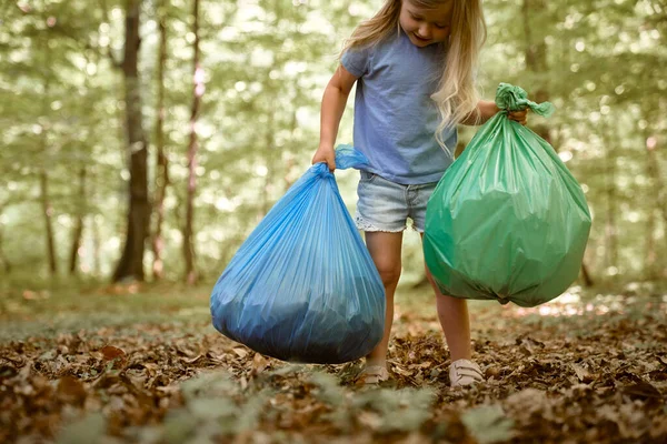 白人女孩在森林里提着垃圾袋 — 图库照片