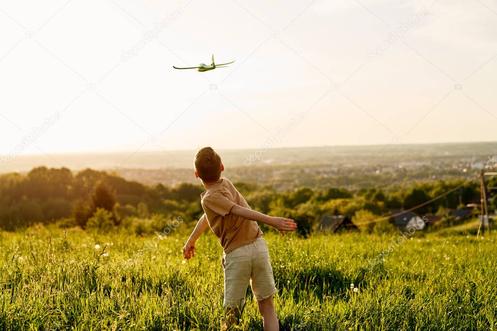 Little boy with toy airplane at meadow