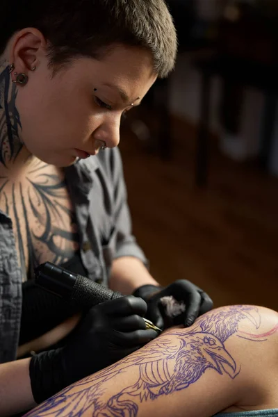 Close up of tattoo artist drawing on arm of client