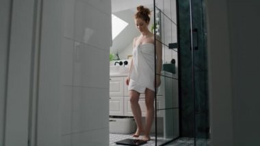 Banyo terazisinde duran beyaz kadın. 4K 'da kırmızı helyum kamerayla çekildi..    