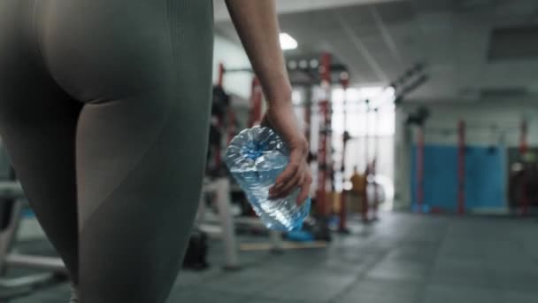 Mujer Joven Que Camina Por Gimnasio Mientras Sostiene Una Botella — Vídeos de Stock