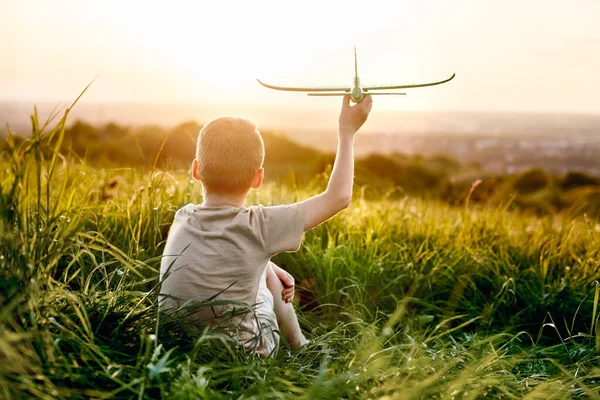 小男孩和玩具飞机坐在草地上 — 图库照片