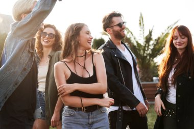 Bir grup beyaz arkadaş dans ediyor ve müzik festivalinde eğleniyorlar.