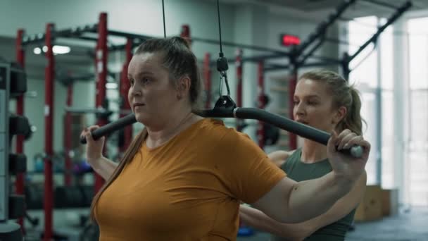 超重的女人在健身房和健身教练一起训练 用4K的红色氦相机拍摄 — 图库视频影像