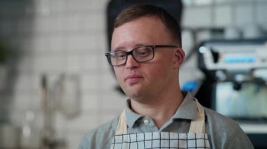 Down sendromlu beyaz bir adam kafede ücretsiz ödeme kabul ediyor. 8K 'da kırmızı helyum kamerayla çekildi..  