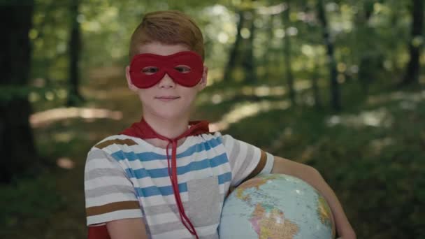 Portrait Ginger Boy Superhero Costume Holding Globe Forest Shot Red — Stock Video