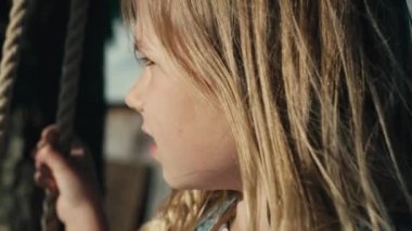 Yaz günü sallanan küçük kıza yakın çekim. 4K 'da kırmızı helyum kamerayla çekildi..   