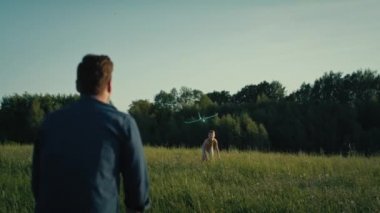 Meadow 'daki oyuncak uçakla oynayan adam. 4K 'da kırmızı helyum kamerayla çekildi..  