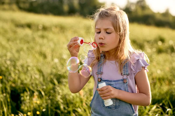 在草地上玩泡泡游戏的白人女孩 — 图库照片